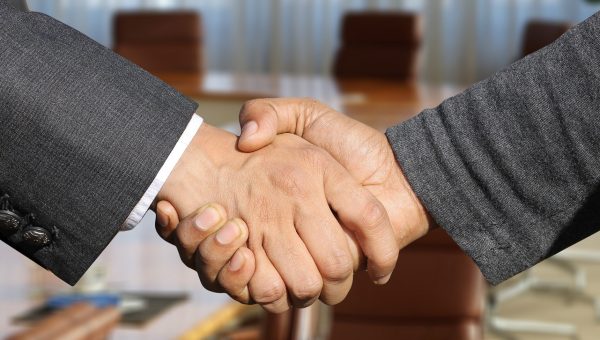 Two people shake hands to signify partnership