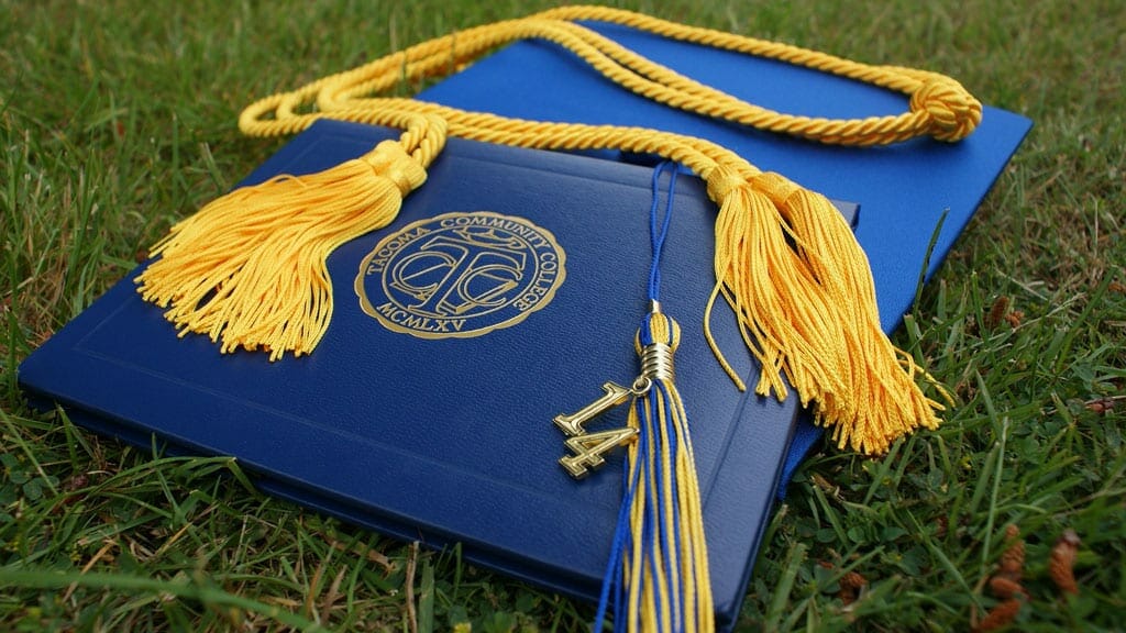 diploma and tassels laying in the grass