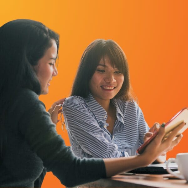 Two women reviewing a printed document on a manilla folder